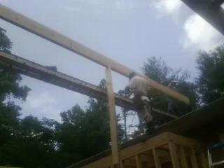 Carpenter setting a ridge beam over a new addition frame — Ice Dam Removal by Roofing Brothers in Scottdale
