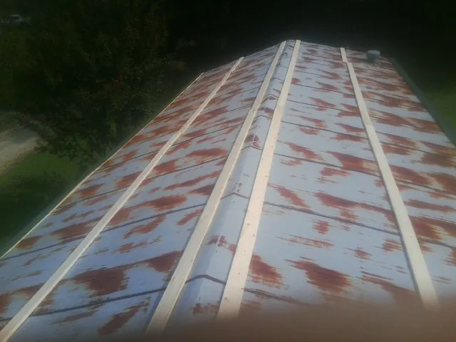 Rusted metal roof panels with new wood purlins before replacement — Storm Damage Roof Repair in Scottdale by Roofing Brothers