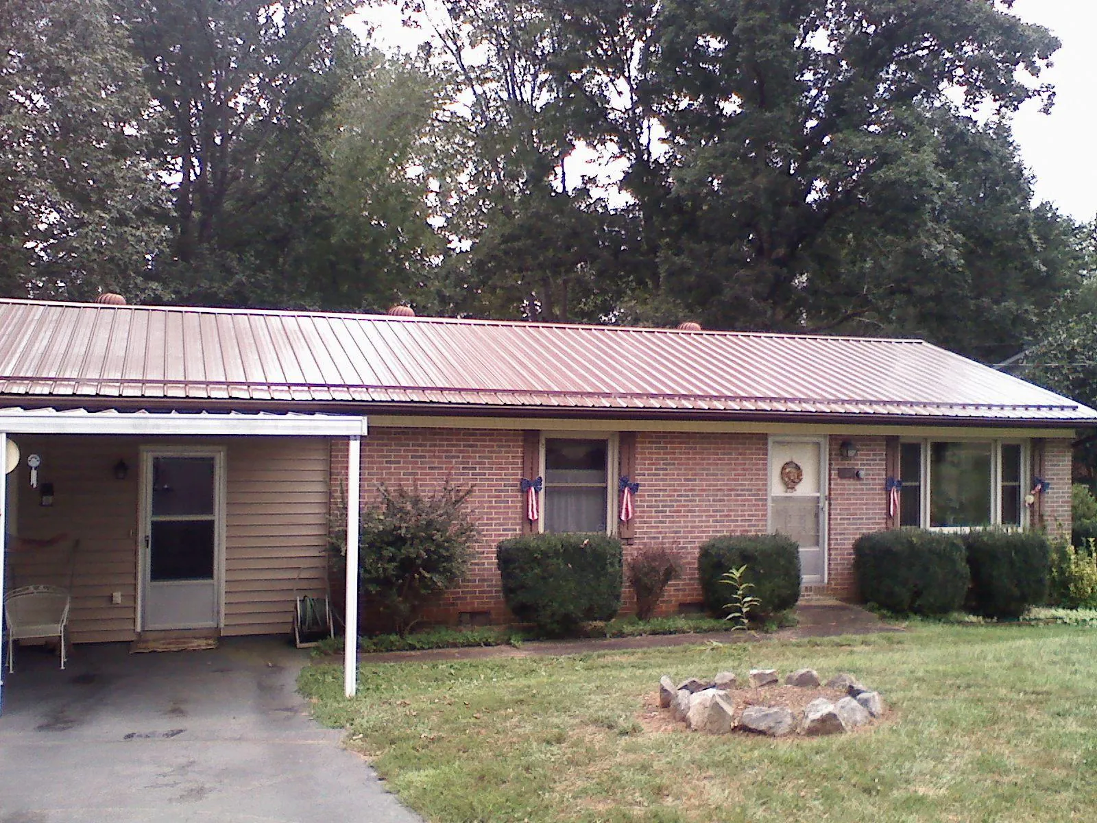 Bronze metal roof and carport on a brick ranch home — Roof Repair work by our crew in Scottdale