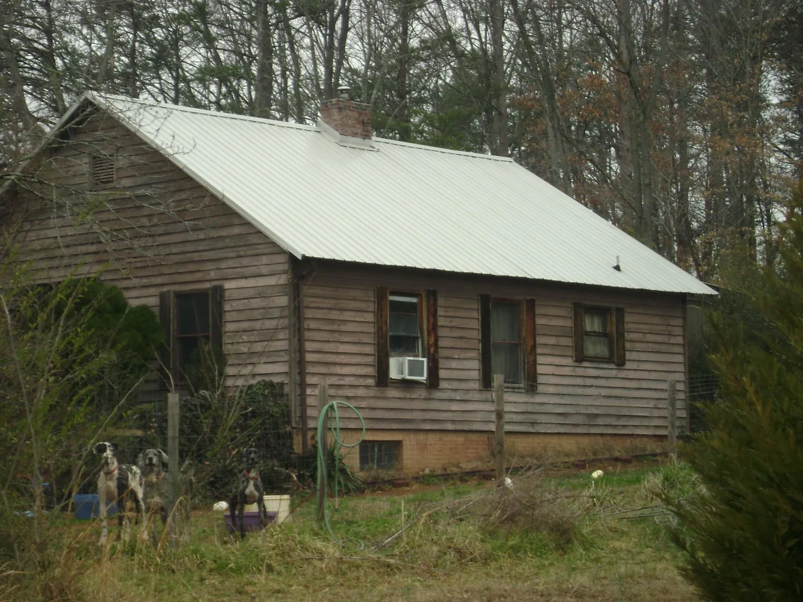 White metal roof on an old wood sided farmhouse, from a Metal Roof Installation job in Scottdale